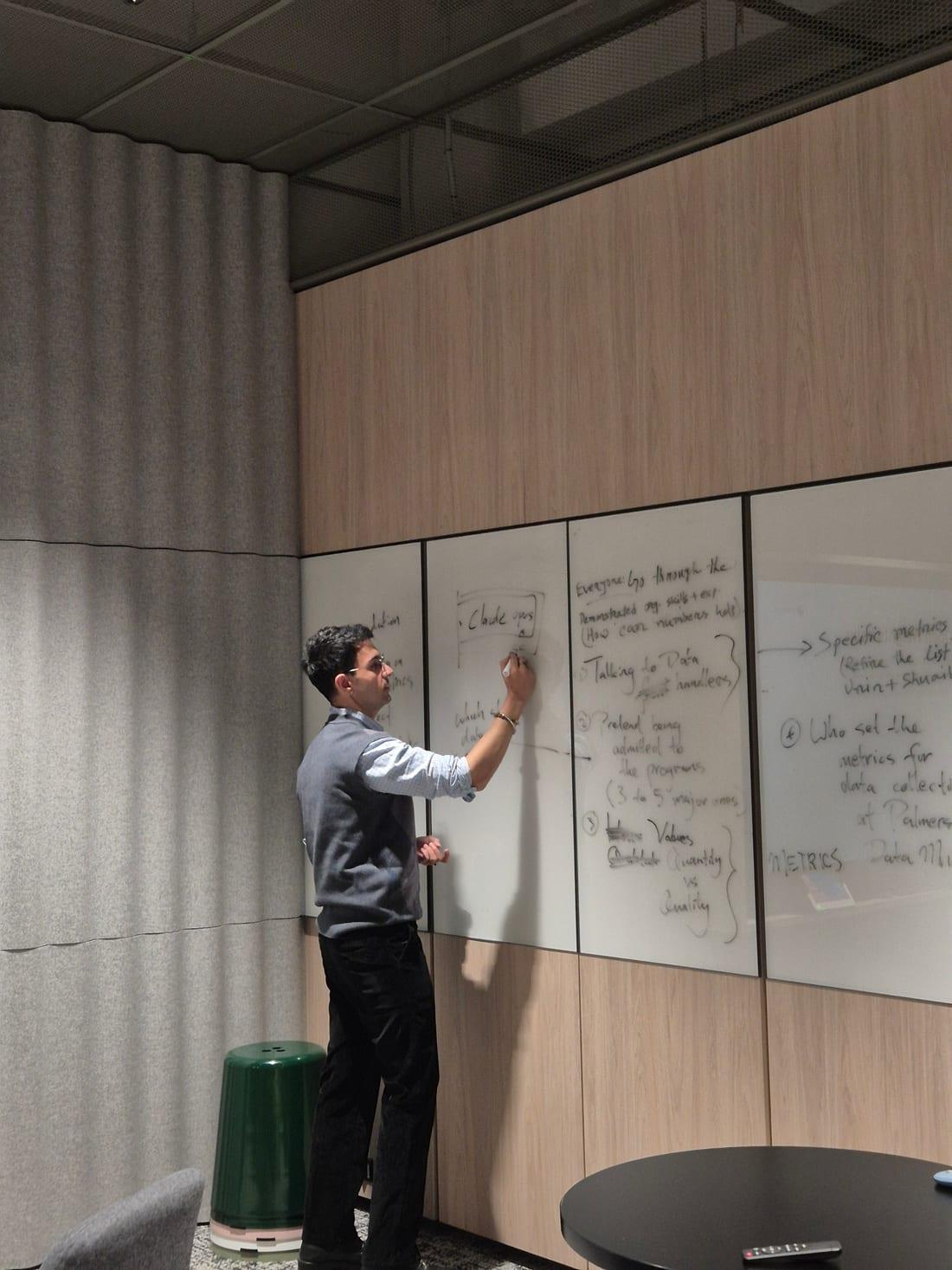 Samreid Manez working through product metrics on a whiteboard